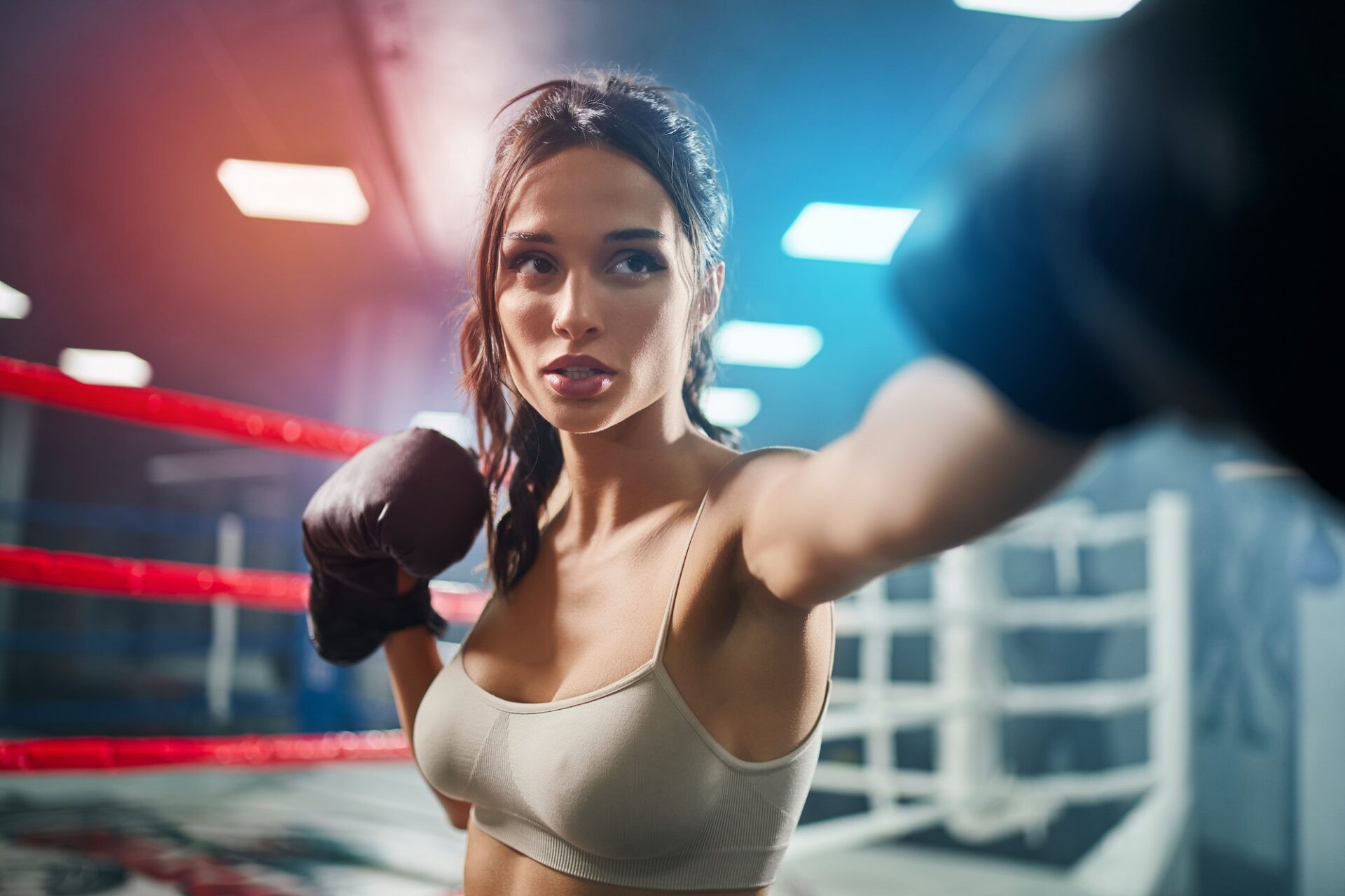 Woman showing hit in boxing gloves